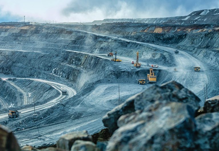 Work of trucks and the excavator in an open pit