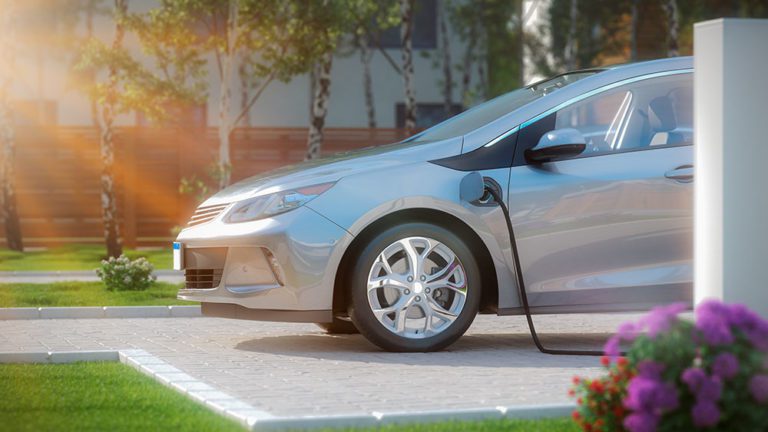 electric car parked in front of home modern low energy suburban