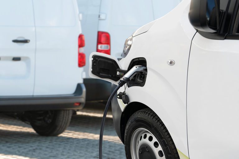 Electric delivery van with connected charging cable.