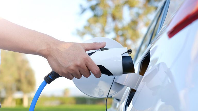 Electric car or ev is charging at station . man use the white po