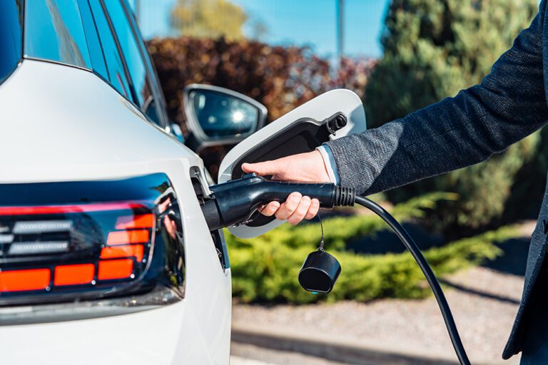 Electrical car charging. Man’s hand inserting the electrical con