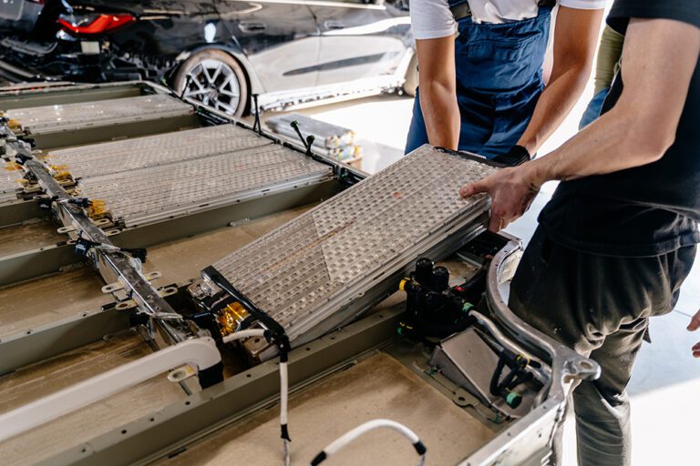 Pack of battery cells module on platform. Assembly of an electric vehicle battery after repair in vehicle repair shop workshop indoor.